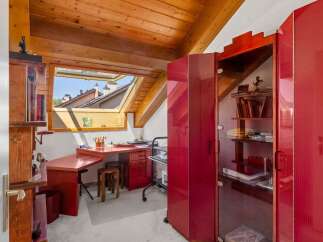 Discover this charming attic workspace, bathed in natural light from a large skylight offering picturesque rooftop views.