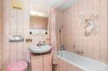 This charming bathroom features a delicate pink tile scheme, creating a warm and inviting atmosphere.
