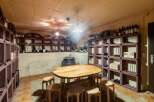 Discover this exceptional wine cellar, featuring a rustic wooden table and stools perfect for tastings.