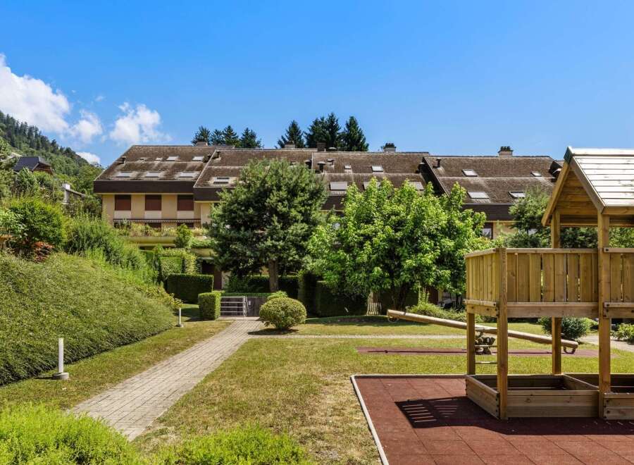 Discover this charming property featuring a well-maintained playground with a sandbox and seesaw, perfect for family fun.