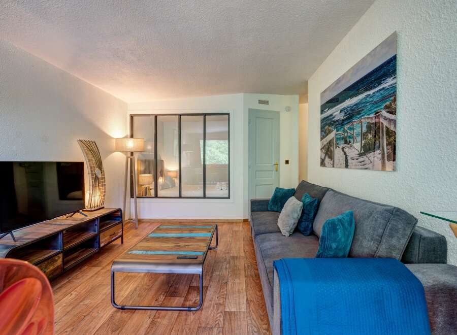 Experience modern living in this stylish living room, featuring a comfortable grey sofa adorned with plush teal and grey cushions, perfect for relaxation.