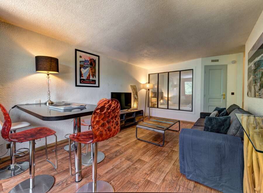 This stylish living area features a modern dining set with unique acrylic chairs, perfect for intimate meals.