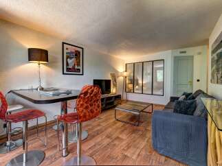 This stylish living area features a modern dining set with unique acrylic chairs, perfect for intimate meals.