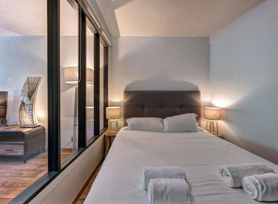 Experience comfort and style in this beautifully appointed bedroom, featuring a plush king-sized bed with crisp white linens and two matching bedside lamps for a warm ambiance.
