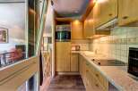 This charming kitchen features light wood cabinetry and a sleek countertop, perfect for meal preparation.