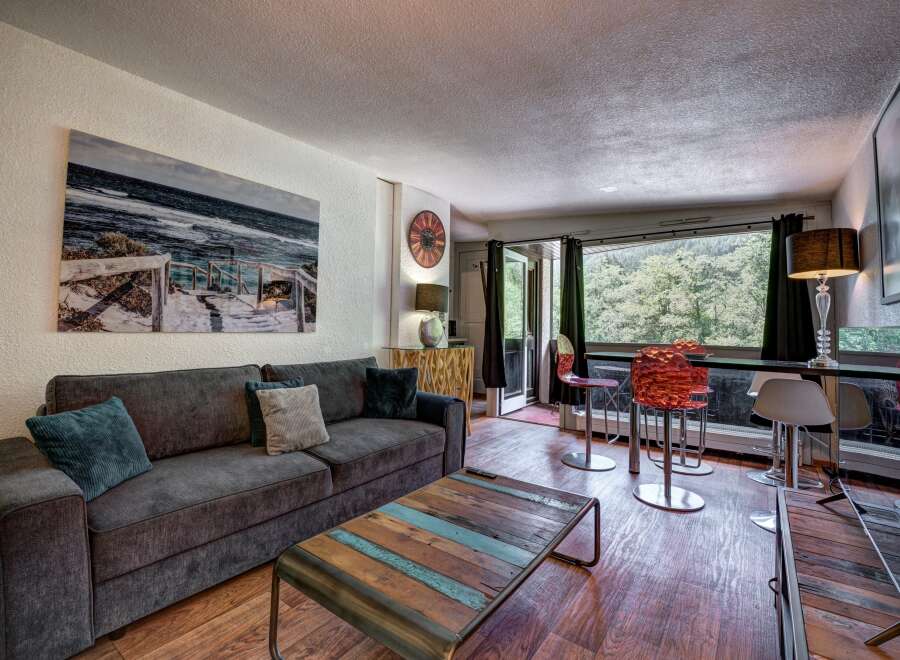 Experience comfortable living in this inviting living room, featuring a plush charcoal sofa adorned with accent pillows and a unique reclaimed wood coffee table.