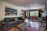 Experience comfortable living in this inviting living room, featuring a plush charcoal sofa adorned with accent pillows and a unique reclaimed wood coffee table.