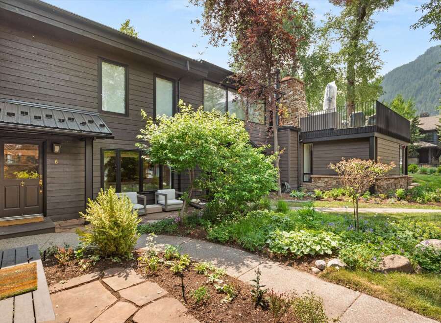 Discover this charming property featuring a dark wood exterior and a welcoming entrance with a covered porch.