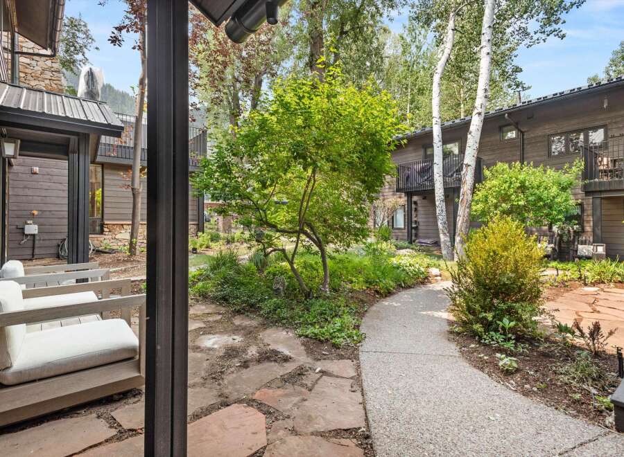 Experience the tranquility of this mountain retreat, featuring a charming courtyard with flagstone pathways and lush greenery.
