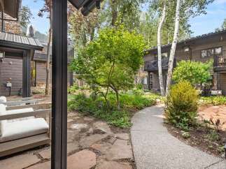 Experience the tranquility of this mountain retreat, featuring a charming courtyard with flagstone pathways and lush greenery.