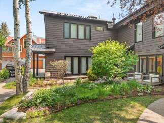 Experience modern living in this stunning home featuring dark wood siding and a sleek metal roof.