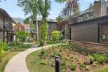 Discover modern living in this beautifully landscaped property, featuring a charming pathway winding through lush gardens.