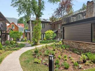Discover modern living in this beautifully landscaped property, featuring a charming pathway winding through lush gardens.