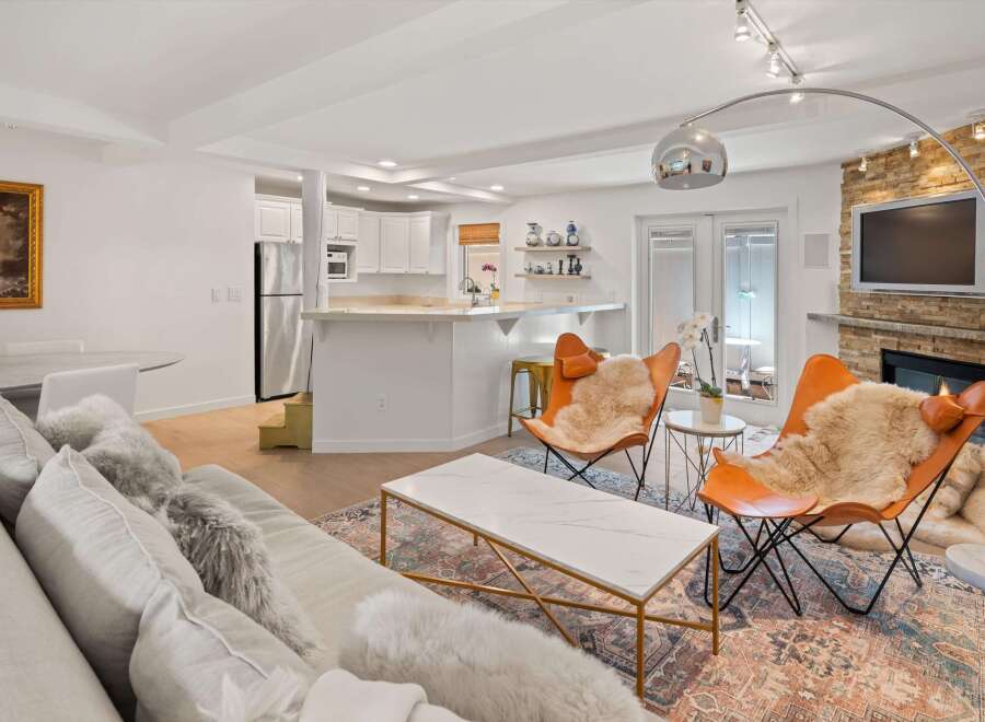 Experience modern living in this beautifully appointed open-concept space, featuring a sleek kitchen with stainless steel appliances and a breakfast bar.