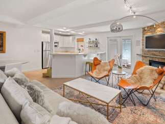 Experience modern living in this beautifully appointed open-concept space, featuring a sleek kitchen with stainless steel appliances and a breakfast bar.