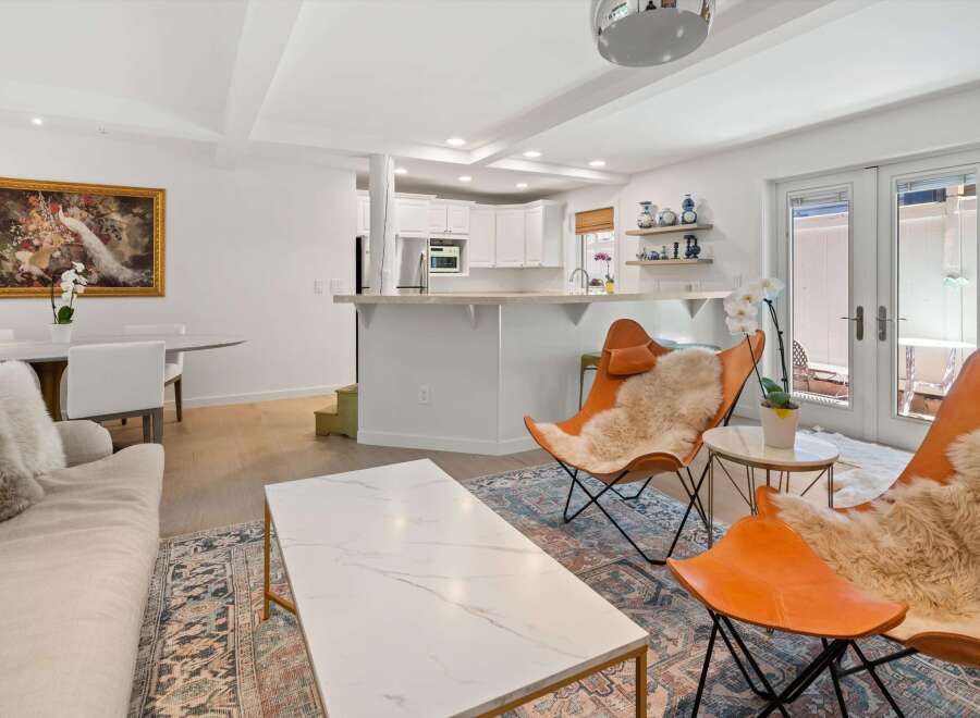 Experience modern living in this open-concept space featuring a stylish living area with comfortable seating and a large marble coffee table.