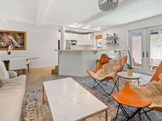 Experience modern living in this open-concept space featuring a stylish living area with comfortable seating and a large marble coffee table.