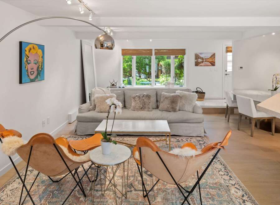 Experience modern living in this beautifully appointed living room, featuring a chic Marilyn Monroe pop art piece and comfortable butterfly chairs.
