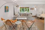Experience modern living in this beautifully appointed living room, featuring a chic Marilyn Monroe pop art piece and comfortable butterfly chairs.