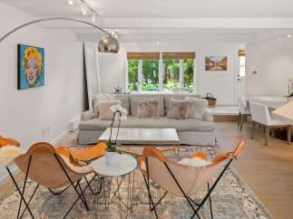 Experience modern living in this beautifully appointed living room, featuring a chic Marilyn Monroe pop art piece and comfortable butterfly chairs.