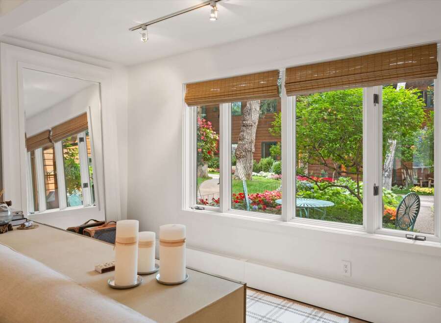 Step into a beautifully appointed living space with a large mirror reflecting the lush garden views.