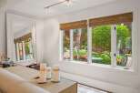 Step into a beautifully appointed living space with a large mirror reflecting the lush garden views.