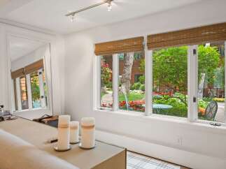 Step into a beautifully appointed living space with a large mirror reflecting the lush garden views.