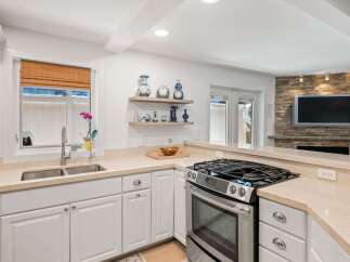 This modern kitchen boasts a sleek stainless steel gas range and a double basin sink, perfect for any home chef.