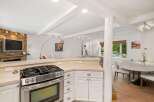 This open-concept kitchen and dining area features a modern gas range and ample counter space, perfect for entertaining.