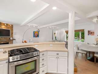 This open-concept kitchen and dining area features a modern gas range and ample counter space, perfect for entertaining.