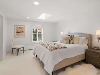 Experience luxury and comfort in this beautifully appointed bedroom, featuring a plush king-sized bed adorned with soft, textured pillows and a cozy throw.