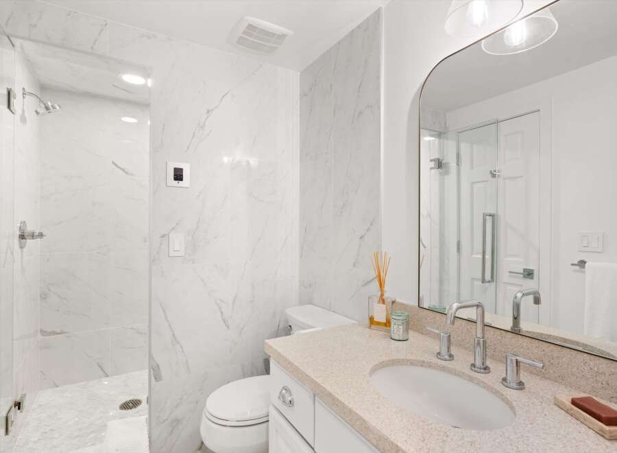 Experience modern luxury in this stunning bathroom, featuring elegant marble tile throughout and a spacious walk-in shower.
