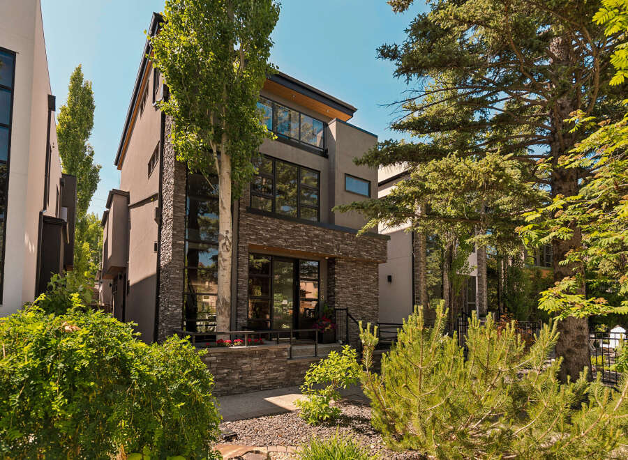 Experience modern luxury in this stunning multi-story residence, featuring a striking contemporary facade with a blend of stone and stucco finishes.