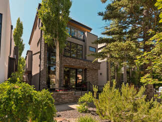 Experience modern luxury in this stunning multi-story residence, featuring a striking contemporary facade with a blend of stone and stucco finishes.