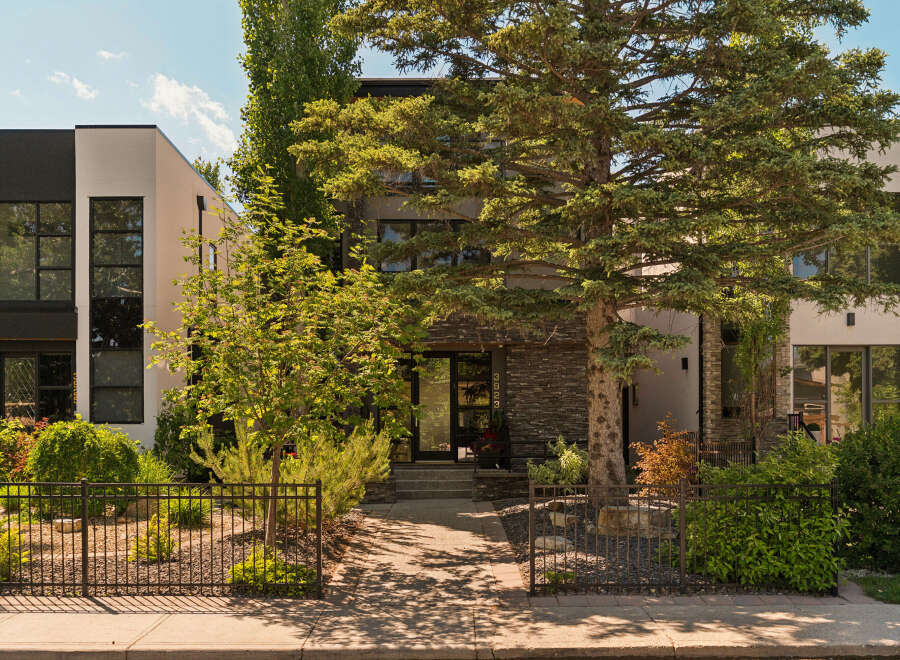 Discover modern luxury in this stunning townhouse featuring a sleek black and white facade complemented by natural stone accents.