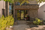 Experience modern luxury with this stunning home featuring a striking stone facade and expansive glass windows.