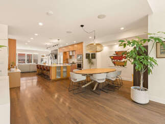 Experience open-concept living in this stunning modern home, featuring a spacious kitchen island perfect for entertaining and a chic dining area.