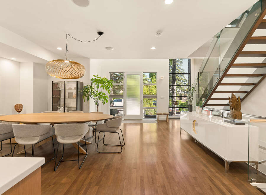 Experience modern living in this stunning open-concept dining and living area, featuring a large oval dining table with comfortable upholstered chairs.