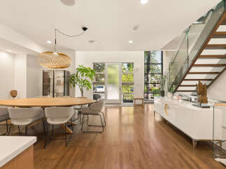 Experience modern living in this stunning open-concept dining and living area, featuring a large oval dining table with comfortable upholstered chairs.
