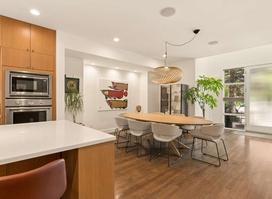 Experience modern living in this spacious dining area, featuring a sleek oval dining table surrounded by comfortable upholstered chairs.