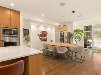 Experience modern living in this spacious dining area, featuring a sleek oval dining table surrounded by comfortable upholstered chairs.