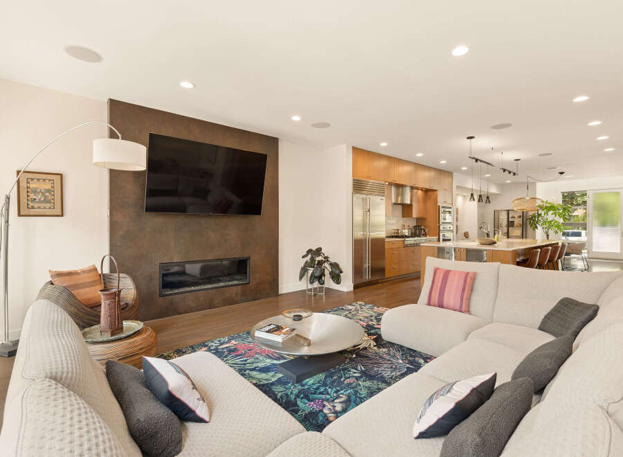 Experience modern living in this open-concept space featuring a sleek fireplace and a large sectional sofa perfect for entertaining.