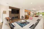 Experience modern living in this open-concept space featuring a sleek fireplace and a large sectional sofa perfect for entertaining.