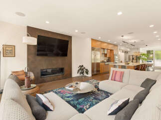 Experience modern living in this open-concept space featuring a sleek fireplace and a large sectional sofa perfect for entertaining.