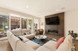 Experience modern living in this spacious living room, featuring a large sectional sofa perfect for gatherings and a sleek fireplace with an integrated TV.