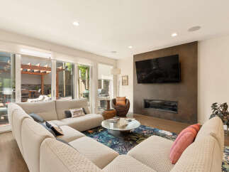 Experience modern living in this spacious living room, featuring a large sectional sofa perfect for gatherings and a sleek fireplace with an integrated TV.