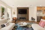 Experience modern living in this stunning open-concept living space, featuring a sleek fireplace and a large flat-screen TV as the focal point.