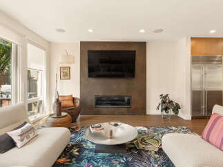 Experience modern living in this stunning open-concept living space, featuring a sleek fireplace and a large flat-screen TV as the focal point.