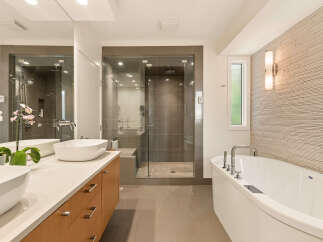 Experience luxury in this modern bathroom featuring a freestanding soaking tub and a spacious glass-enclosed shower with sleek tilework.