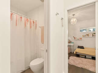 Step into a charming bedroom featuring a cozy bed with a vibrant yellow quilt and a plush pink rug.